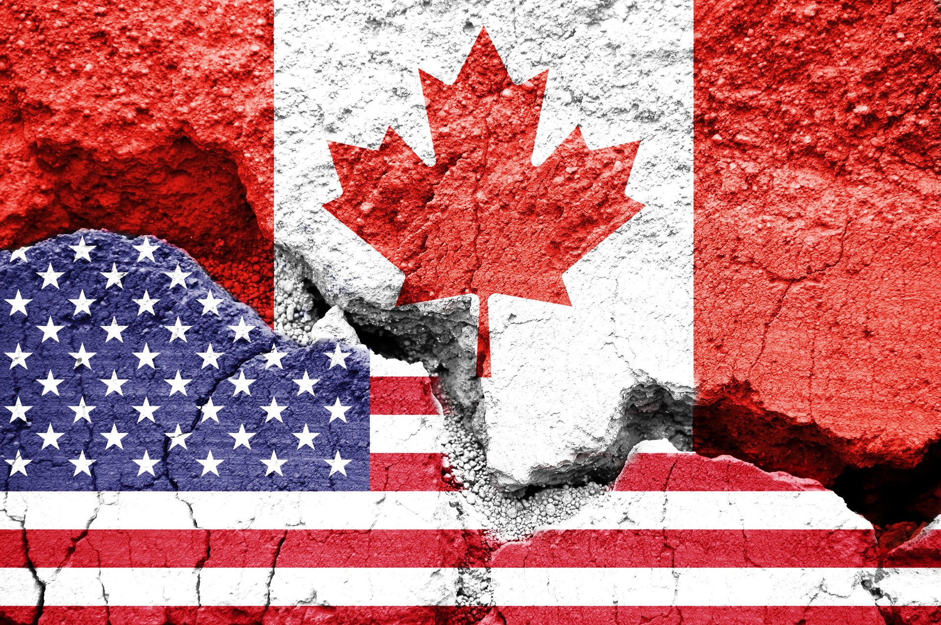 US American and Canadian flags on cracked background. Concept of  diplomatic crisis, tariffs and commercial trade war between United States and Canada